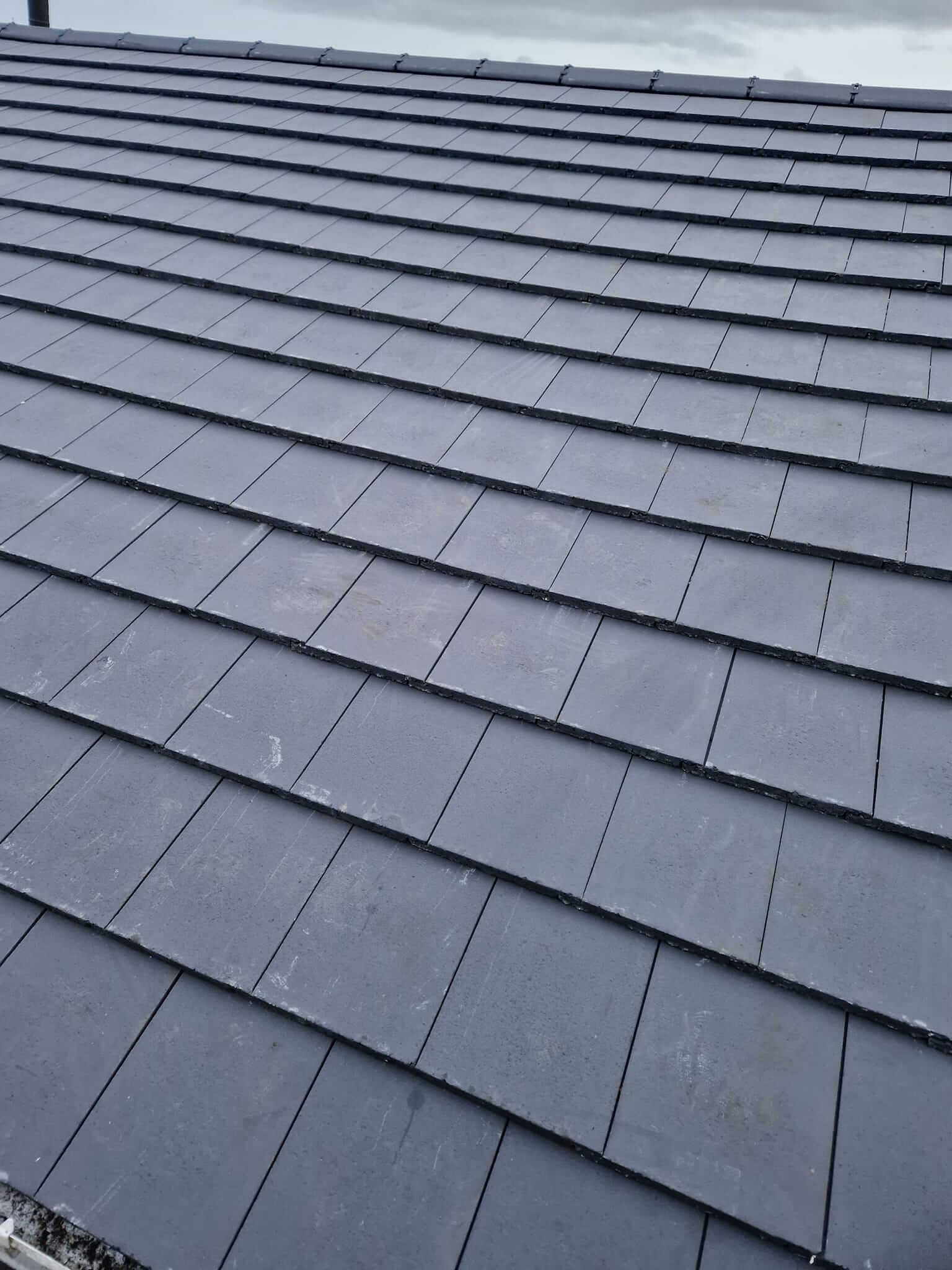 Roof repair work showing new flashing and tile replacement